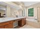Well lit bathroom featuring a double sink, bathtub, and enclosed shower at 20314 Chestnut Grove Dr, Tampa, FL 33647