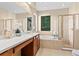 Bright primary bathroom with dual sinks, soaking tub, and glass shower at 20314 Chestnut Grove Dr, Tampa, FL 33647