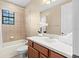 Bright bathroom with a tub and shower, vanity with sink, toilet, and a window with blinds at 20314 Chestnut Grove Dr, Tampa, FL 33647