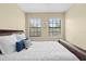 Bright bedroom featuring a comfortable bed with white bedding, and two windows with wooded views at 20314 Chestnut Grove Dr, Tampa, FL 33647