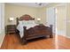 A bedroom with a king size bed, hardwood floors, lamps and end tables at 20314 Chestnut Grove Dr, Tampa, FL 33647