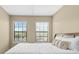 Bright bedroom with neutral walls, two large windows, and a comfortable bed with decorative pillows at 20314 Chestnut Grove Dr, Tampa, FL 33647