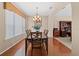 Dining area with wood floors, a dark wood table, and a decorative chandelier next to a large bookcase at 20314 Chestnut Grove Dr, Tampa, FL 33647