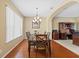 Elegant dining room with chandelier, wood floors, and view into the office area at 20314 Chestnut Grove Dr, Tampa, FL 33647