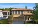 Charming two-story home showcasing a clay tile roof, arched entry, two-car garage, and mature landscaping at 20314 Chestnut Grove Dr, Tampa, FL 33647
