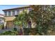 Inviting two-story house with a clay tile roof, arched entry, two-car garage, and tropical landscaping at 20314 Chestnut Grove Dr, Tampa, FL 33647