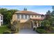 Two-story home with a terracotta roof, arched entryway, a two-car garage, and manicured landscaping at 20314 Chestnut Grove Dr, Tampa, FL 33647