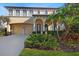 Elegant two-story home with a tile roof, arched entryway, and a well-manicured front yard at 20314 Chestnut Grove Dr, Tampa, FL 33647