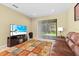 Cozy living room with a large TV, plush leather sofa, and sliding glass doors to a backyard at 20314 Chestnut Grove Dr, Tampa, FL 33647