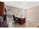 This office features ample natural light, tile floors, a dark wooden desk, hutch, and a decorative chandelier at 20314 Chestnut Grove Dr, Tampa, FL 33647