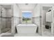 Modern bathroom with a soaking tub, a walk-in shower, and a serene view, creating a spa-like oasis at 21 Crescent S Pl, St Petersburg, FL 33711