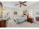 Comfortable bedroom featuring neutral carpet, ceiling fan, blinds, and warm lamps for a cozy ambiance at 7233 15Th Ne Ct, St Petersburg, FL 33702
