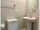 Clean half bath featuring a pedestal sink, modern fixtures, and a neutral color scheme at 13621 Willow Bluestar Loop, Riverview, FL 33579