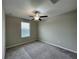 A spacious room featuring carpeted floors, a ceiling fan, and a window to allow for plenty of natural light at 13621 Willow Bluestar Loop, Riverview, FL 33579