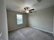 A spacious room featuring carpeted floors, a ceiling fan, and a window to allow for plenty of natural light at 13621 Willow Bluestar Loop, Riverview, FL 33579