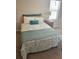 Cozy bedroom with a patterned comforter, decorative pillows, and natural light from the window at 13621 Willow Bluestar Loop, Riverview, FL 33579
