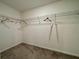 Walk-in closet featuring carpeted floors and metal racks to provide ample storage space and organization at 13621 Willow Bluestar Loop, Riverview, FL 33579