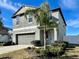 Charming two-story home with a 2 car garage, lush landscaping, and a cozy front porch at 13621 Willow Bluestar Loop, Riverview, FL 33579