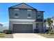 Two story home features a gray exterior, well manicured lawn, and a two car garage at 13621 Willow Bluestar Loop, Riverview, FL 33579