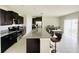 Spacious kitchen with dark cabinetry, granite countertops, a large island, and stainless steel appliances at 13621 Willow Bluestar Loop, Riverview, FL 33579