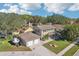 Overhead view of a two-story home with lush landscaping, a two-car garage, and a boat parked in the driveway at 13945 75Th Ave, Seminole, FL 33776