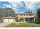 Charming two-story home with a well-manicured lawn, detached garage, and inviting front porch at 13945 75Th Ave, Seminole, FL 33776