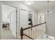 Well-lit upstairs hallway with open doorways, leading to various rooms, with carpet and neutral colored walls at 13945 75Th Ave, Seminole, FL 33776