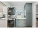Laundry room with stackable washer/dryer, shaker cabinets, and a window at 13945 75Th Ave, Seminole, FL 33776