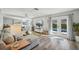Bright living room boasts wood floors, a large sectional couch and French doors to the outdoor pool area at 13945 75Th Ave, Seminole, FL 33776