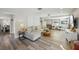 Bright living room with wood floors, large sectional sofa, recessed lighting, and view to entry hall at 13945 75Th Ave, Seminole, FL 33776