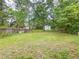 Expansive backyard with green grass and storage shed, surrounded by mature trees at 262 Pryor St, Brooksville, FL 34601