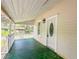 This is a view of the green painted porch of a charming home with a decorative oval window on the door at 262 Pryor St, Brooksville, FL 34601
