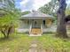 Inviting home featuring a classic covered front porch and lush landscaping at 262 Pryor St, Brooksville, FL 34601