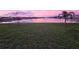 Calm lake view at sunset, with a fountain feature and grass in foreground at 38311 Sonnet Landing Ave, Zephyrhills, FL 33540