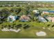 Aerial view showing homes with pools and screened lanais, surrounded by lush greenery and a golf course at 4098 Las Palmas Way, Sarasota, FL 34238
