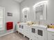 Bright bathroom featuring double sinks, white cabinetry, and modern fixtures at 4098 Las Palmas Way, Sarasota, FL 34238