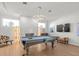 Game room showcasing a pool table, unique lighting fixtures, and white tiled fireplace at 4098 Las Palmas Way, Sarasota, FL 34238