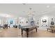 Spacious game room with hardwood floors, decorative lighting, a pool table, and an open floor plan at 4098 Las Palmas Way, Sarasota, FL 34238