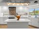 Bright kitchen features an island, stainless steel appliances, and sleek white cabinetry at 4098 Las Palmas Way, Sarasota, FL 34238