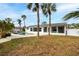 Back of home with a screen patio, and in-ground pool, surrounded by palm trees at 5321 Dover Ne St, St Petersburg, FL 33703