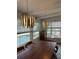 Bright dining room features two modern chandeliers, a wood table, and windows overlooking the pool at 5321 Dover Ne St, St Petersburg, FL 33703