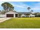 Charming single-story home featuring a well-manicured lawn and a two car garage at 5321 Dover Ne St, St Petersburg, FL 33703