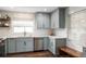 Well-lit kitchen showcasing blue cabinets, stainless steel appliances, and modern backsplash at 5321 Dover Ne St, St Petersburg, FL 33703