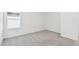 Simple bedroom featuring gray carpet, a window with natural light, and a neutral color palette at 6233 Golden Beach Dr, Apollo Beach, FL 33572