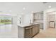 Bright kitchen features stainless steel appliances, gray cabinets, an island, and an open view to the backyard at 6233 Golden Beach Dr, Apollo Beach, FL 33572