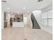 Spacious open-plan living room featuring tile floors, a staircase, and modern recessed lighting fixtures at 6233 Golden Beach Dr, Apollo Beach, FL 33572