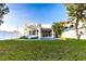 Modern backyard with lush green lawn, a sparkling swimming pool, and white privacy fence at 2246 Fiesta Dr, Sarasota, FL 34231