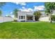 A spacious backyard with a well-maintained lawn, modern home, and refreshing swimming pool at 2246 Fiesta Dr, Sarasota, FL 34231