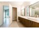 Bright bathroom featuring double sink vanity and tile flooring, with access to toilet room at 2246 Fiesta Dr, Sarasota, FL 34231