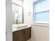 Modern powder room with stylish vanity, square sink, sleek fixtures and a sunlit window at 2246 Fiesta Dr, Sarasota, FL 34231